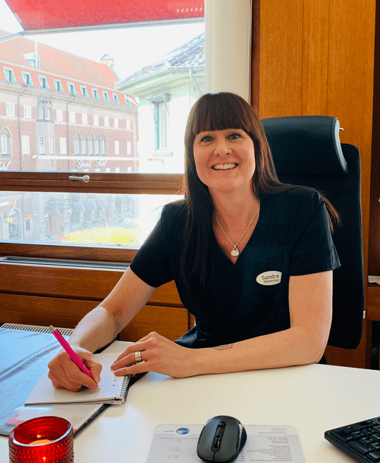 Sandra Nilsson sitter vid ett skrivbord på en gynekologmottagning i Helsingborg